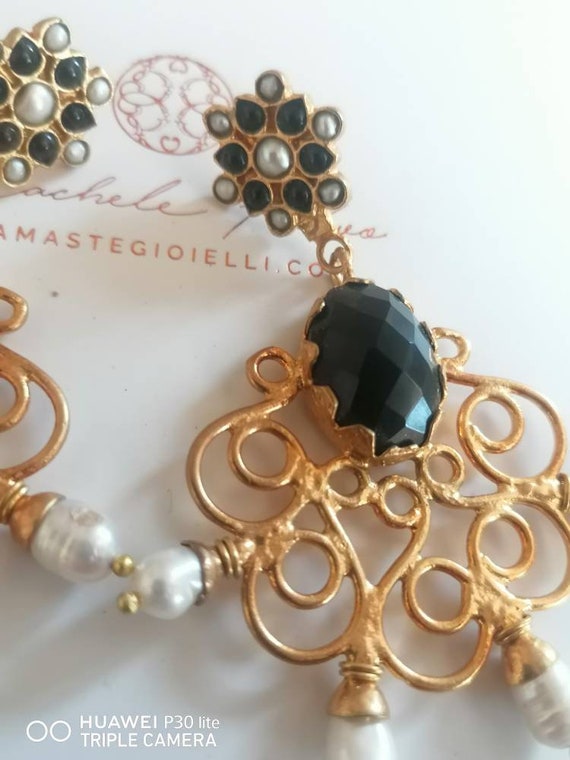 Spectacular earrings in matte gold over bronze and finished with pearls and natural onyx