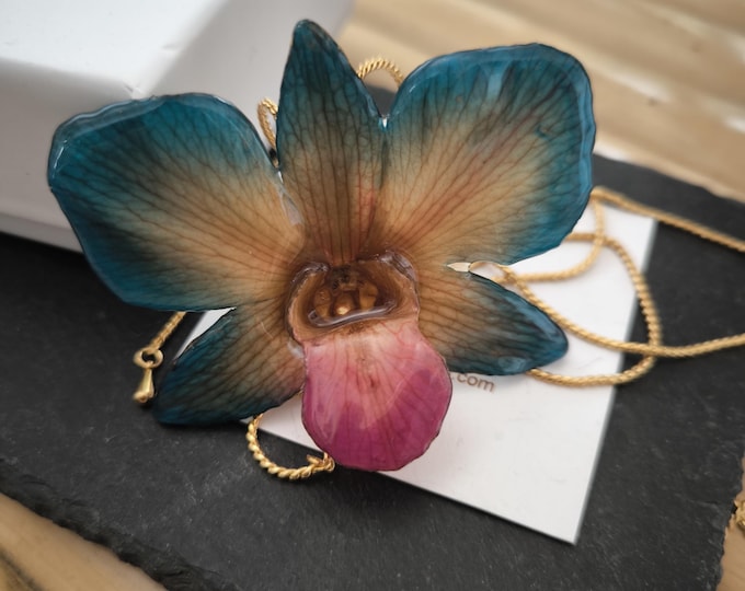 Blue, orange, purple mouth dendrobium orchid necklace embedded in resin and finished with adjustable gold-on-bronze sliders.