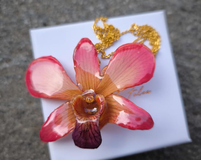 Orange and pink orchid necklace embedded in resin and gold-plated steel chain.