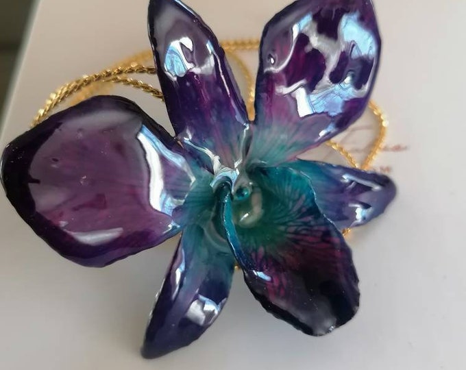 Spectacular blue/purple Dendrobium orchid embedded in resin with galvanized gold ups and downs adjustable at will