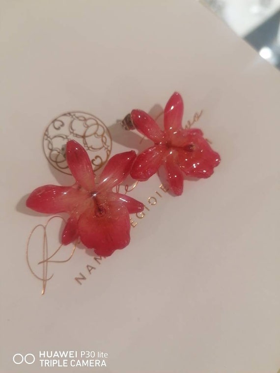 Mini light red Cattlaya orchids embedded in resin with silver hook on the lobe