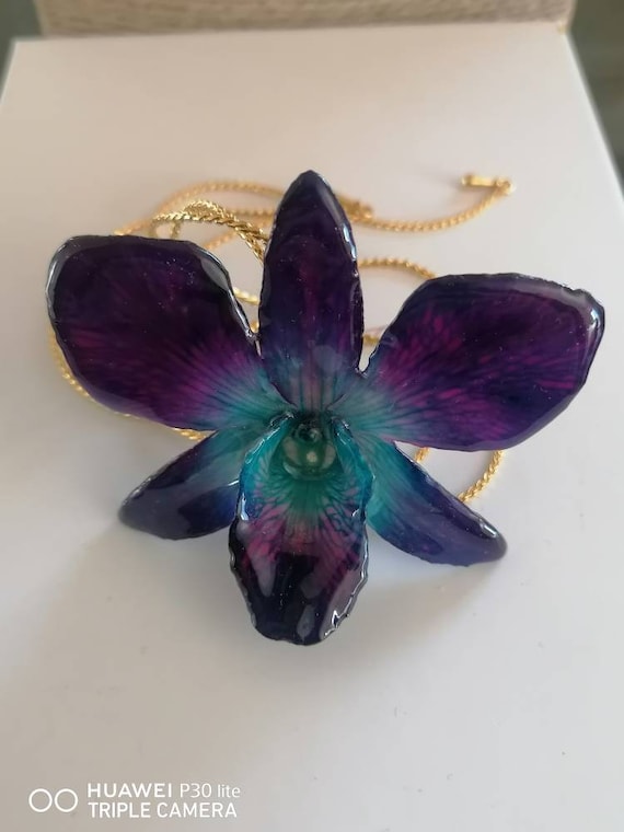 Spectacular blue/purple Dendrobium orchid incorporated in resin with galvanized gold latches adjustable as desired