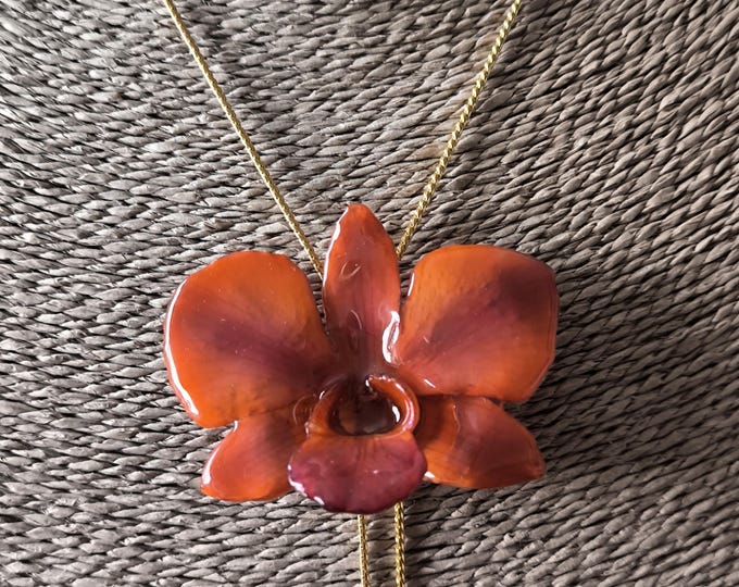 Orange orchid necklace in resin and finished with an adjustable gold-on-bronze slider.