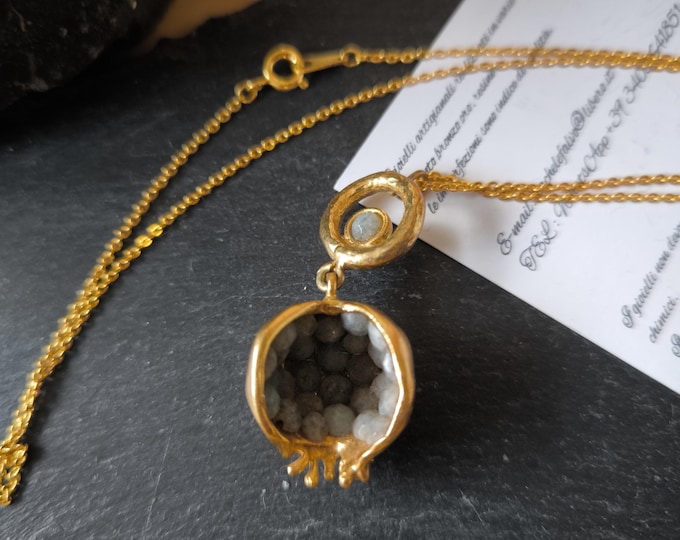 Open pomegranate pendant necklace finished with natural light grey olivine.