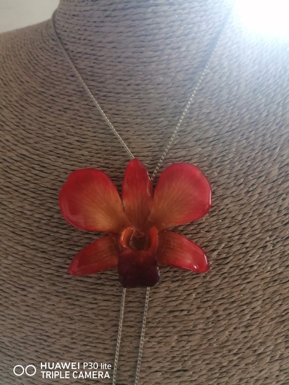 Orange/yellow orchid necklace embedded in resin with adjustable silver on bronze slider.