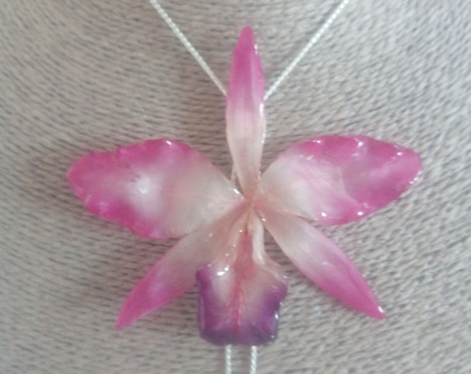 Spectacular pink Queen Cattlaya orchid embedded in resin and finished with silver and bronze plating.