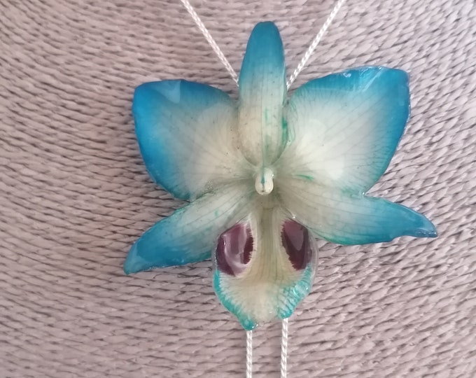 Resin orchid necklace. Galvanized silver pendant finished with a light blue hybrid orchid with yellow veins.