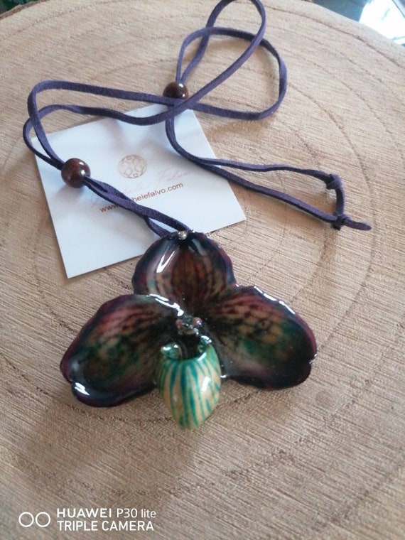 Spectacular natural orchid incorporated in resin with purple leather necklace and natural seeds.