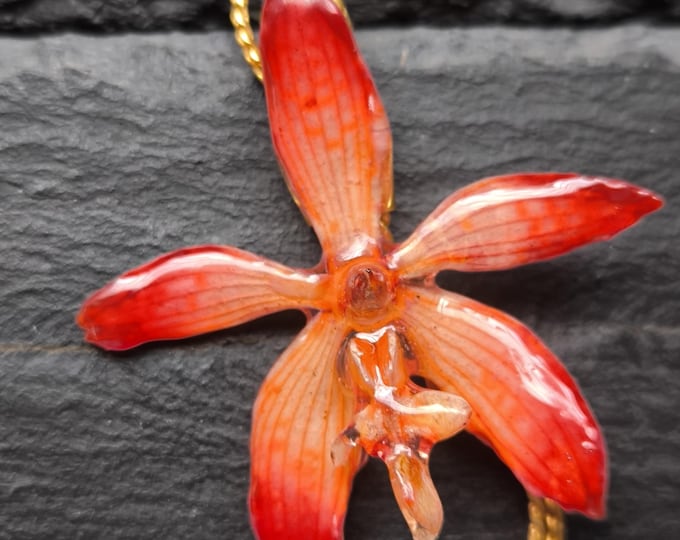 ciondolo saliscendi oro orchidea arancione inglobata in resina.