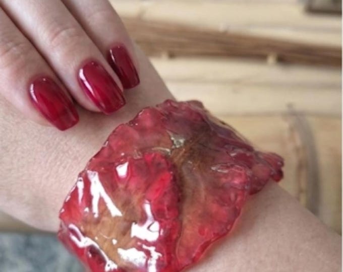 bracelet with real lobster red orchid petals embedded in resin.