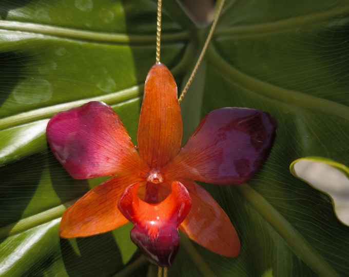 Natural orange-purple orchid embedded in resin and adjustable gold slider