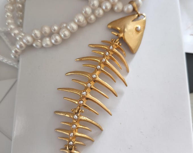 Very elegant and refined pearl necklace with a central fishbone finished with natural pearls.