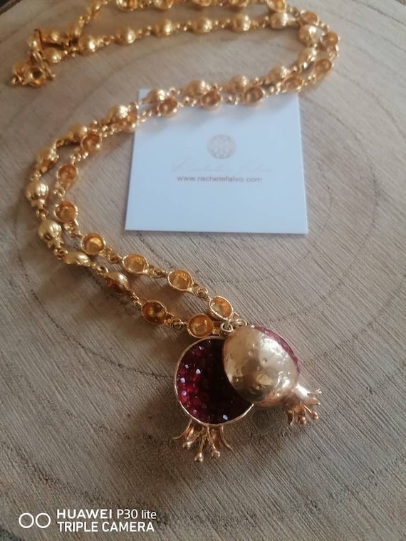 Spectacular long necklace adjustable at will gold on bronze and finished with natural garnets, open pomegranate studded with stones.