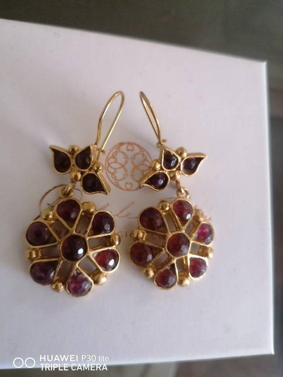 Spectacular earrings in matte gold on bronze and finished with natural garnets