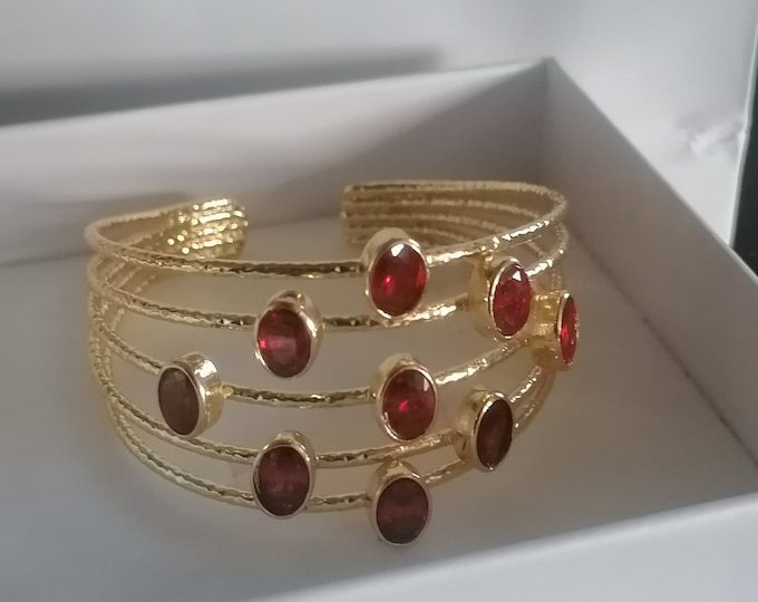 Adjustable bracelet made of gold threads on bronze and finished with natural faceted red garnets