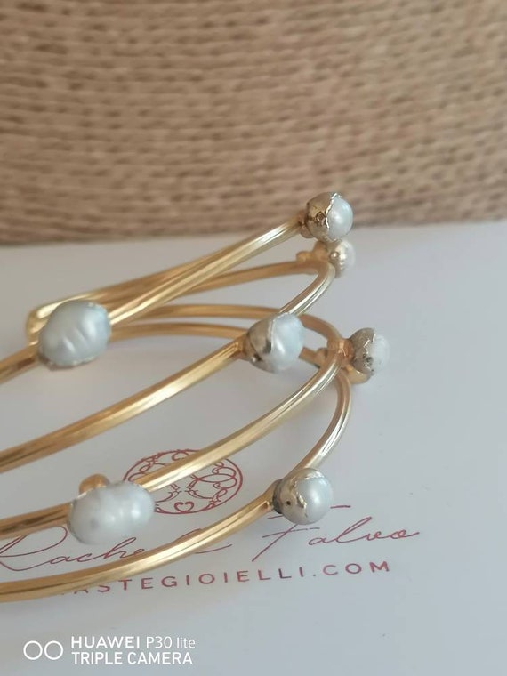 Adjustable bracelet in gold on bronze and finished with natural pearls