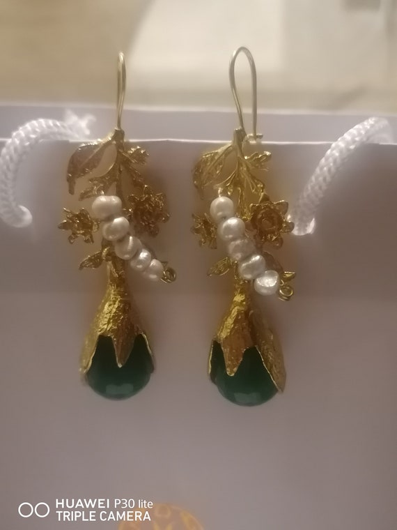 Earrings in matte gold over bronze and finished with white pearls and faceted green jades