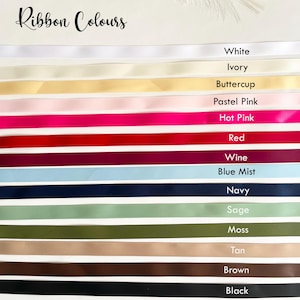 Pu&ograve; includere: Una selezione di nastri colorati, tra cui bianco, avorio, giallo burro, rosa pastello, rosa acceso, rosso, vino, blu nebbia, blu navy, salvia, muschio, marrone chiaro, marrone e nero. Il testo "Ribbon Colours" &egrave; in alto.