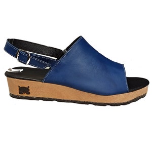 May include: Blue leather wedge sandals with a buckle strap and a black and brown platform sole.
