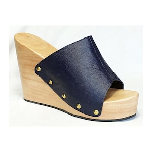 Könnte beinhalten: Marineblaue Ledersandalen mit Keilabsatz und Holzplattform und goldenen Nieten.