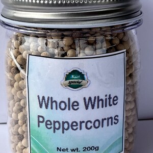 May include: A clear jar filled with whole white peppercorns, topped with a silver lid. The label reads "Whole White Peppercorns" and "Net wt. 200g". The jar is filled with small, round, off-white peppercorns.
