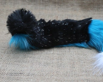 May include: A fluffy black and turquoise faux fur tail with a white tip. The tail is about 20 inches long and is perfect for adding a touch of whimsy to any costume or outfit.