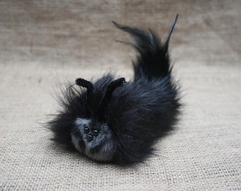 Könnte beinhalten: Ein schwarzes, flauschiges Wesen mit langem, schwarzem Fell und einem Schwanz. Das Wesen hat zwei große, schwarze Augen und eine kleine, schwarze Nase.