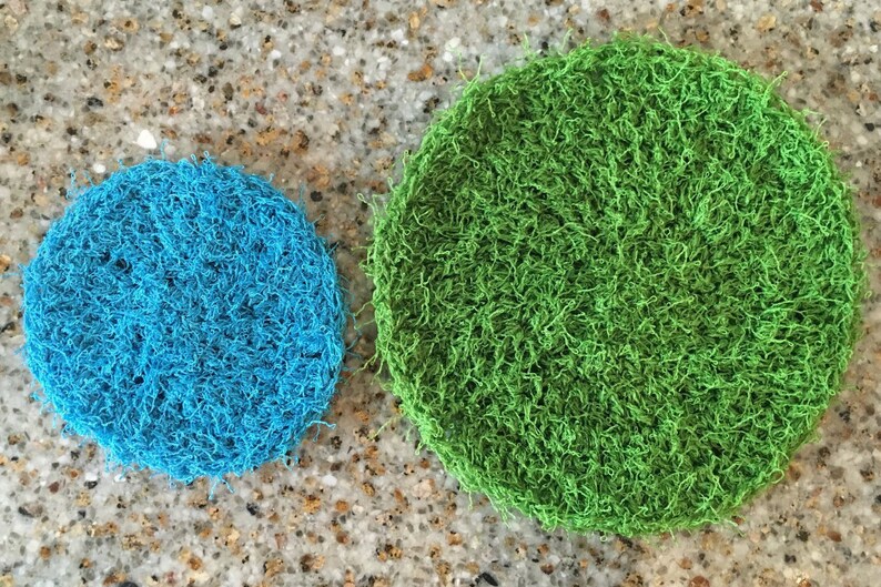 May include: Two round, crocheted scrubbers. One is blue and the other is green.