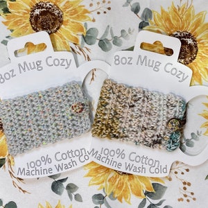 May include: Two white 8oz mug cozies with crocheted fabric. The cozies are made of 100% cotton and are machine washable. The cozies are displayed on a white background with a sunflower pattern.