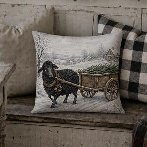 May include: A square throw pillow featuring a black sheep pulling a wooden cart filled with pine branches through a snowy landscape. The pillow has a light-colored background and is displayed on a wooden bench alongside other pillows.