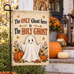 Puede incluir: Una bandera de jard&iacute;n rectangular con una ilustraci&oacute;n de un fantasma blanco, calabazas naranjas y hojas de oto&ntilde;o. El texto dice: The ONLY Ghost here is The HOLY GHOST. El dise&ntilde;o incluye cuatro estrellas doradas y detalles florales en crema.