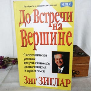 Puede incluir: Una portada de libro amarilla con el título "Do Vstrechi na Vershine" en letras rojas y negras. El libro trata sobre la mentalidad psicológica, la imagen de uno mismo, el logro de objetivos y el sentido común. El autor es Zig Ziglar.