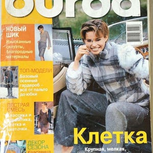May include: A Burda magazine issue 10/2000 with a yellow border and white text. The cover features a person wearing a grey plaid zip-up jacket with white fur sleeves and grey trousers. The text includes 'burda', 'ВЕСЬ МИР МОДЫ', and 'Клетка'.