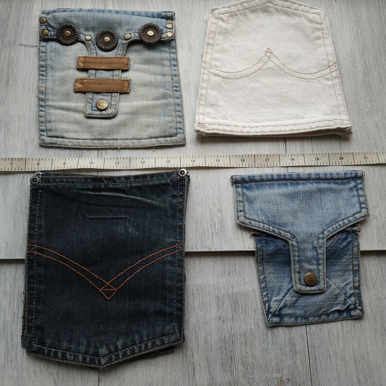 May include: Four different denim pockets, two are light blue, one is dark blue, and one is white. The pockets are all different sizes and shapes.