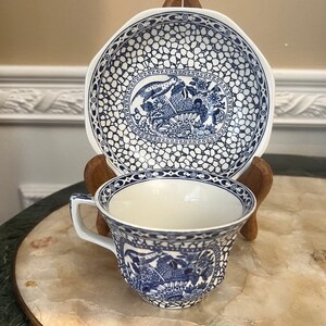 May include: A blue and white teacup and saucer set with a floral pattern. The saucer has a scalloped edge and the cup has a handle.
