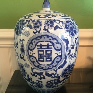 May include: A blue and white porcelain ginger jar with a lid. The jar is decorated with floral patterns and the Chinese character for "double happiness".