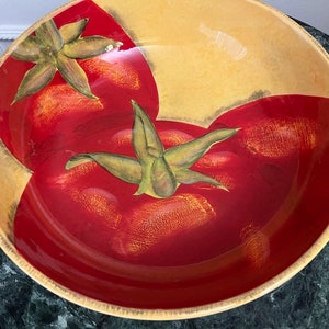 Könnte beinhalten: Eine große, runde Keramikschüssel mit gelbem Rand und einem roten und grünen Tomaten-Design. Die Schüssel ist mit zwei Tomaten verziert, eine auf jeder Seite, mit grünen Blättern und Stielen.