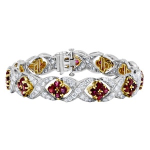 May include: A white gold and yellow gold bracelet with a diamond and ruby design. The bracelet features a series of interlocking links, each set with a cluster of rubies surrounded by diamonds.