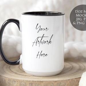 May include: White ceramic mug with a black rim and handle. The mug is sitting on a wooden surface and has the text "Your Artwork Here" written on it.