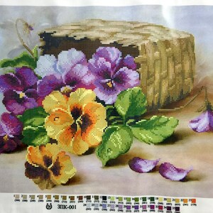 May include: A close-up of a still life painting featuring a bouquet of purple, yellow, and white pansies with green leaves. The pansies are arranged around a wooden stump. The background is a light brown colour.