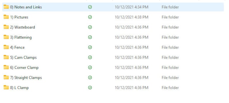 May include: A screenshot of a file explorer window displaying a list of folders. The folders are labelled with numbers and names, including "Notes and Links", "Pictures", "Wasteboard", "Flattening", "Fence", "Cam Clamps", "Corner Clamp", "Straight Clamps", and "L Clamp". Each folder has a tick next to it and a date and time stamp showing when it was last modified.