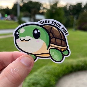 May include: A green and brown cartoon turtle sticker with big eyes and the text "TAKE YOUR TIME" on the shell.