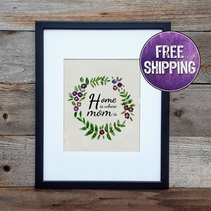 Home is where mom is with a circle of flowers around it featured on a cream colored canvas sheet