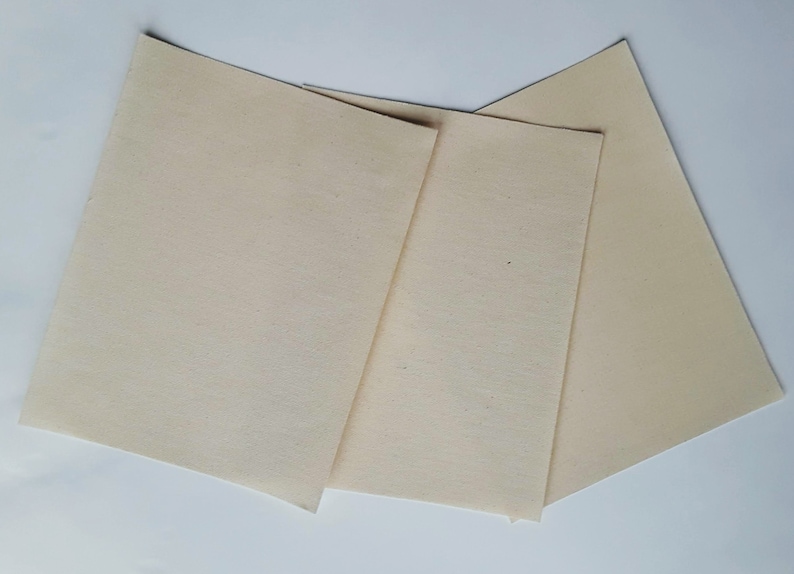 May include: Three off-white fabric squares, possibly for quilting or crafts.