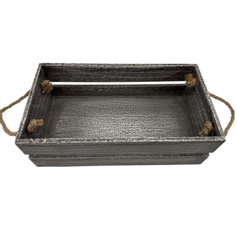 May include: A rectangular wooden crate with a distressed gray finish. The crate has rope handles on each side. The interior of the crate is also gray. The crate is designed for storage or display.