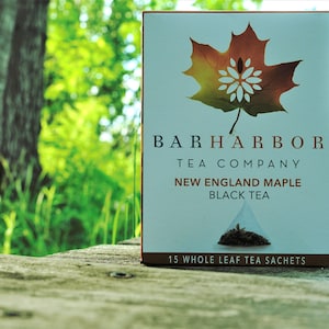 May include: A box of Bar Harbor Tea Company New England Maple Black Tea with a maple leaf design. The box contains 15 whole leaf tea sachets.