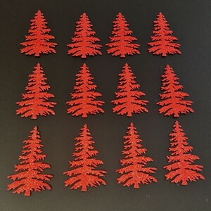 May include: Twelve red glitter Christmas tree cutouts arranged on a black surface. Each tree has a detailed silhouette with branches and a textured, sparkling finish. Ideal for holiday crafts and decorations.