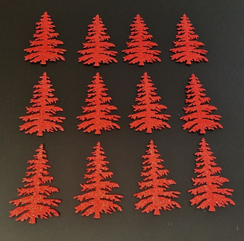 May include: Twelve red glitter Christmas tree cutouts arranged on a black surface. Each tree has a detailed silhouette with branches and a textured, sparkling finish. Ideal for holiday crafts and decorations.