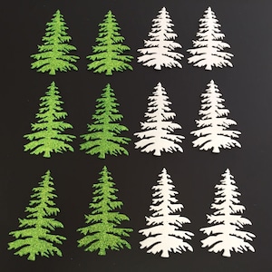 May include: A collection of twelve Christmas tree cutouts. The trees are in two colors: green with glitter and white. The trees are arranged in three rows of four trees each, against a black background. The trees are all the same shape.