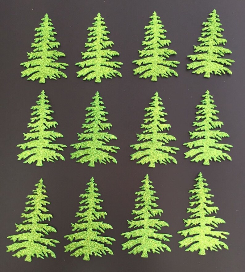 May include: Twelve glittery green Christmas tree cutouts arranged on a dark background. The trees are detailed with branches and a textured, sparkling finish. Ideal for holiday crafts and decorations.